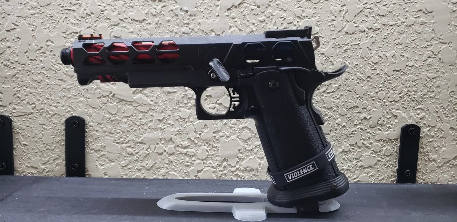 A completed Black Phantoms Hi-Capa build on a stand