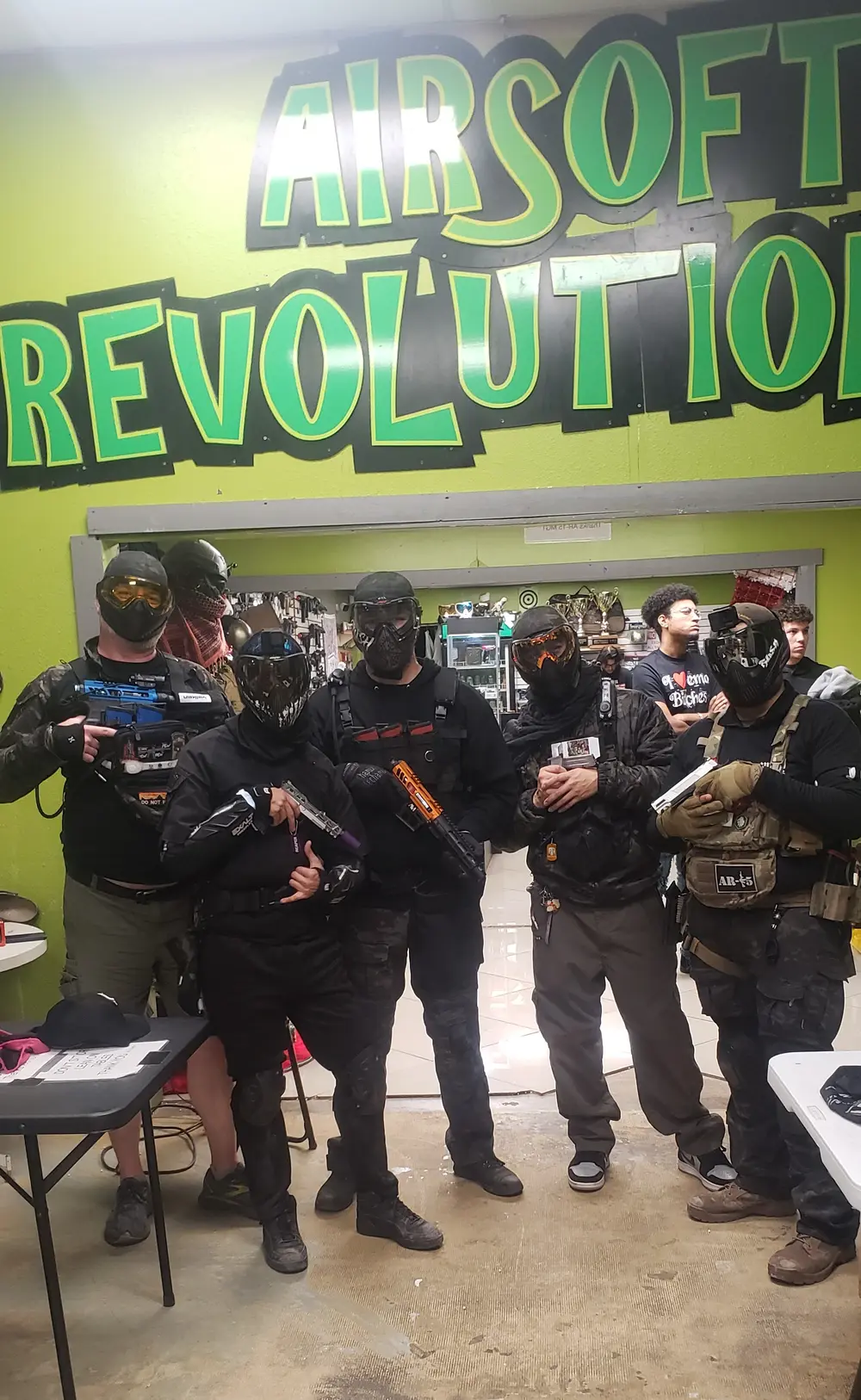Players gathered under the Airsoft Revolution sign at the home field